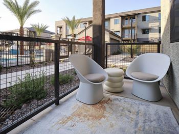 two toilets sitting on a balcony next to a fence